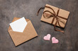 Open brown envelope with blank card mockup on dark background. Valentine's Day. Top view, flat lay.
