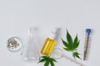 Cannabis CBD oil and hemp leaves with laboratory glass top view. Laboratory glassware and cannabis sativa herb and hemp seeds. Cannabis herbal alternative medicine.