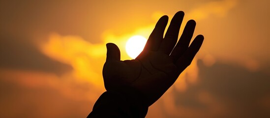 Wall Mural - Christian devotee's hand raised in prayer towards Jesus' silhouette.