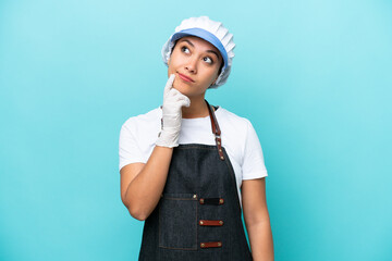 Wall Mural - Fishwife Argentinian woman isolated on blue background having doubts while looking up