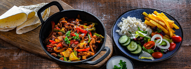 Fajita with peppers and onions served on a hot iron skillet