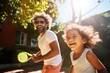 Sunlit laughter fills the air as a father and child enjoy a game of tennis, with the child gleefully chasing the ball