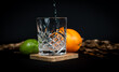 Cocktail glass on a black background with citrus, while pouring liquid.