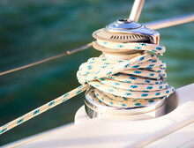 Sailboat Detailed Parts. Close Up On Winch And Rope Of Yacht Over Blue Sea