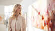 A graceful woman in a chic outfit observes wall art in a sunlit room, reflecting a moment of tranquility and culture.