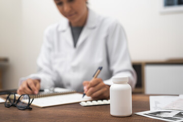 Poster - Pharmaceutical Close-Up: A close-up view of a doctor's workspace, featuring a jar of pills, vitamins, ultrasound test results, and medical documentation