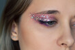 © Марина Демешко - Close up of a young caucasian woman with purple and pink eye shadow and glitter on the eyelids. Party, holiday festive makeup