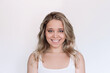 © Марина Демешко - Portrait of a young attractive cheerful caucasian smiling blonde woman with wavy hair isolated on a white background. Charming girl with green eyes