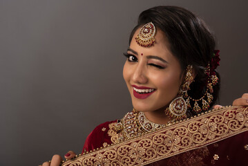 Wall Mural - Young Indian female in ethnic Indian wear celebrating festival of Diwali. Indian female with bridal make-up and bridal wear