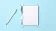 © Pasinee - Minimalist Workspace with Blank Notebook and Pencil on Pastel Blue Background – Ideal for Creativity and Design Concepts in Modern Offices and Artistic Blogs
