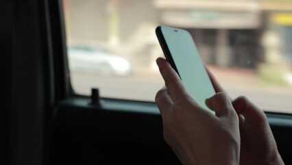 Hand using phone in a car on the road, person using mobile phone in car 