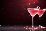 Fototapeta  - two red cosmopolitan Valentines day cocktails in martini glasses with bokeh copy space left