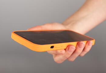 Poster - Hand holding mobile phone, smartphone, surfing internet, browsing online, cellphone in orange case