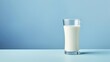 A tall glass of fresh milk stands against a soft blue background, representing purity, freshness, and the wholesome goodness of dairy.