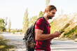 © fotofabrika - Hiker man with backpack checks the route on his phone on the walking trail