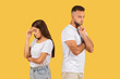 © Prostock-studio - Concerned young couple in white t-shirts standing back to back with worried expressions