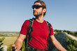 © fotofabrika - Bearded traveler with a backpack and sunglasses on the top of a mountain