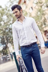 Canvas Print - Handsome young man walking on the street, looking away.