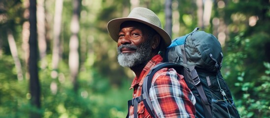 Hiking with a black man in the forest for freedom, health, and sports training; enjoying exercise, peace, and wellness with a senior hiker in nature for travel, summer break, and adventure.