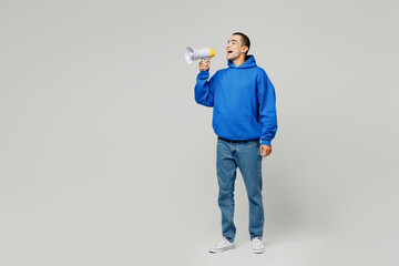Full body young middle eastern man he wear blue hoody casual clothes hold in hand megaphone scream announces discounts sale Hurry up isolated on plain solid white background studio. Lifestyle concept.
