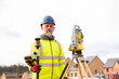 © Iryna - Surveyor builder site engineer with theodolite total station at construction site outdoors during surveying work