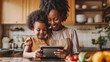© mikhailberkut - Happy mother with his cute daughter using smart pad for cooking, modern kitchen background