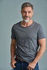 Portrait of happy casual older bearded man with gray hair smiling, Mid adult, mature age guy standing, isolated on gray background.