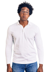 Poster - Handsome african american man with afro hair wearing casual clothes and glasses puffing cheeks with funny face. mouth inflated with air, crazy expression.