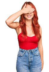 Sticker - Young redhead woman wearing casual clothes smiling and laughing with hand on face covering eyes for surprise. blind concept.