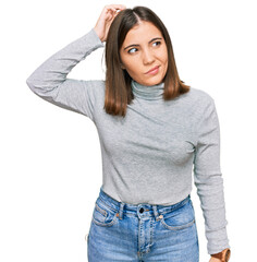 Wall Mural - Young beautiful woman wearing casual turtleneck sweater confuse and wondering about question. uncertain with doubt, thinking with hand on head. pensive concept.