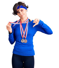 Sticker - Beautiful young woman with short hair wearing winner medals with angry face, negative sign showing dislike with thumbs down, rejection concept