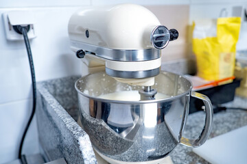 Mixer in restaurant kitchen. Equipment for preparing dough. Professional mixer stands on table. Restaurant kitchen equipment. Mixer beats sauce. Confectionery devices. Catering technology