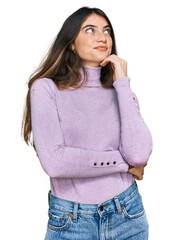 Poster - Young beautiful teen girl wearing turtleneck sweater with hand on chin thinking about question, pensive expression. smiling and thoughtful face. doubt concept.