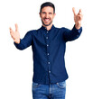 © Krakenimages.com - Young handsome man wearing casual shirt looking at the camera smiling with open arms for hug. cheerful expression embracing happiness.