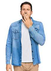 Wall Mural - Young handsome man wearing casual denim jacket bored yawning tired covering mouth with hand. restless and sleepiness.