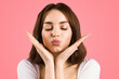 © Prostock-studio - A young woman with closed eyes and a serene expression holds her hands near her face