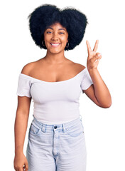 Canvas Print - Young african american girl wearing casual clothes smiling with happy face winking at the camera doing victory sign. number two.