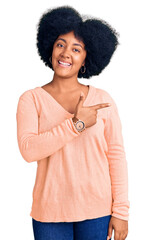 Poster - Young african american girl wearing casual clothes cheerful with a smile of face pointing with hand and finger up to the side with happy and natural expression on face