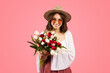 © Prostock-studio - Radiant young woman with a joyful smile, wearing a straw hat and round sunglasses