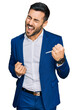 © Krakenimages.com - Young hispanic man wearing business jacket celebrating surprised and amazed for success with arms raised and eyes closed. winner concept.