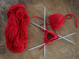 Fototapeta Lawenda - Yarn's Journey into Forming a Delightful Small Red Knitted Hat