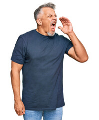 Canvas Print - Middle age grey-haired man wearing casual clothes shouting and screaming loud to side with hand on mouth. communication concept.