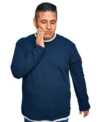 Poster - Young latin man wearing casual clothes touching mouth with hand with painful expression because of toothache or dental illness on teeth. dentist