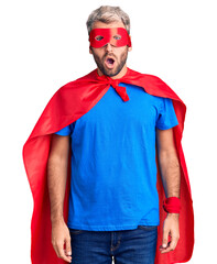 Poster - Young blond man wearing super hero custome afraid and shocked with surprise expression, fear and excited face.