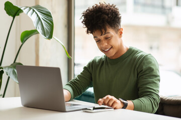 Sticker - Happy millennial black man using gadgets at cafe