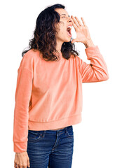 Wall Mural - Young beautiful hispanic woman wearing casual clothes shouting and screaming loud to side with hand on mouth. communication concept.