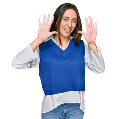 Sticker - Young hispanic girl wearing casual clothes showing and pointing up with fingers number ten while smiling confident and happy.