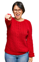 Young beautiful hispanic woman with short hair wearing casual sweater and glasses pointing displeased and frustrated to the camera, angry and furious with you