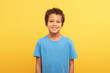 © Prostock-studio - Portrait of smiling boy in blue shirt against yellow background