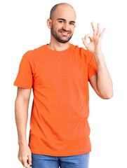 Canvas Print - Young handsome man wering casual t shirt smiling positive doing ok sign with hand and fingers. successful expression.